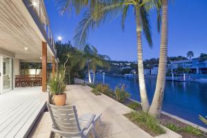a patio with palm trees and a view of the water at 20 Wesley Court, Noosa Heads in Noosa Heads