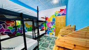 Cette chambre dispose de 2 lits superposés et d'un mur coloré. dans l'établissement Samay Hostel, à Juayúa