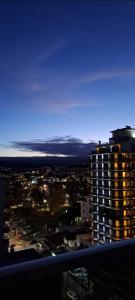 un perfil urbano por la noche con un edificio alto en Opera Villa Carlos Paz en Villa Carlos Paz