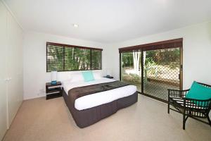 a bedroom with a bed and a large window at 21 Arakoon Crescent, Sunshine Beach in Noosa Heads