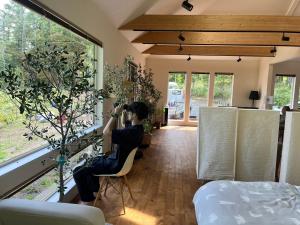 a man sitting in a chair taking a picture of a bedroom at hororo style in Tsurui