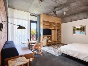 a bedroom with a bed and a desk and a tv at The Carpenter Hotel in Austin