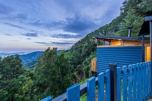 a blue fence in front of a house on a mountain at Tiny House Jaulares in Rivas