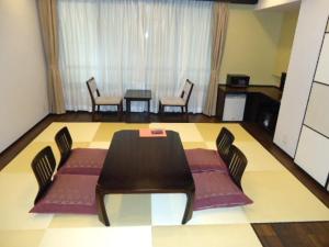 a dining room with a table and chairs in a room at Yamagisi Ryokan in Fujikawaguchiko