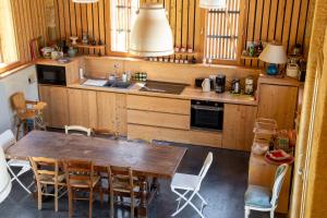 a kitchen with a wooden table and chairs and a sink at Chambre d'hotes La Grange Milou in Beynac-et-Cazenac