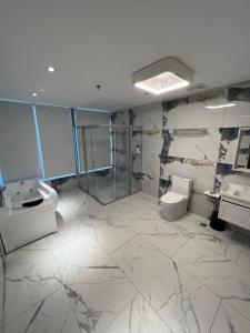 a bathroom with two sinks and a toilet and a shower at City Park Hotel Residences in Manila