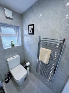 uma casa de banho com um WC branco e uma janela em (ZONE 2) STYLISH 2 BED FLAT IN THE HEART OF LEWISHAM em Londres