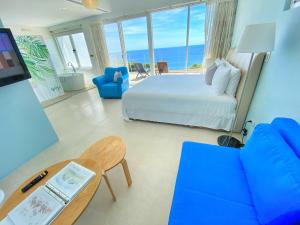 ein Schlafzimmer mit einem Bett, einem Sofa und einem Tisch in der Unterkunft Kenting Ocean Paradise Resort in Altstadt von Hengchun