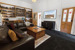 ein Wohnzimmer mit einem Ledersofa und einem Couchtisch in der Unterkunft Noble View in Bairnsdale