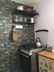 a kitchen with a stove and a kettle on the wall at Humilde espacio en el corazón de Minas in Minas