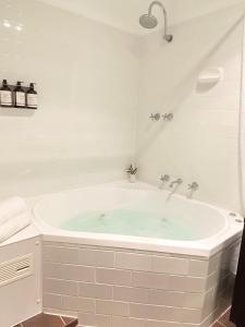 a white bathroom with a tub in a room at Angaston Mews Apartments in Angaston