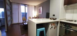 a kitchen with a white counter and a refrigerator at José Miguel Carrera Depto in Santiago