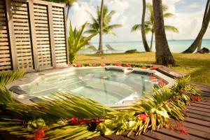 una vasca idromassaggio su una terrazza accanto alla spiaggia di Hotel Kia Ora Resort & Spa ad Avatoru
