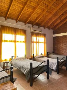1 dormitorio con 2 camas en una habitación con ventanas en Hostel Bahía Ballenas en Puerto Pirámides