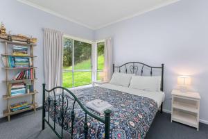 1 dormitorio con cama y ventana en A Little Touch Of Paradise en Apollo Bay