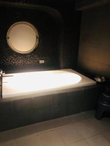a bath tub in a bathroom with a mirror at fannys hotel in Yokohama