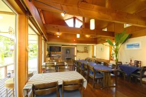 a dining room with wooden tables and chairs at Pension Field in Hokuto