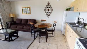 cocina y sala de estar con mesa y sofá en One-Bedroom Apartment, en Honolulu