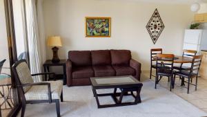 sala de estar con sofá, mesa y sillas en One-Bedroom Apartment, en Honolulu