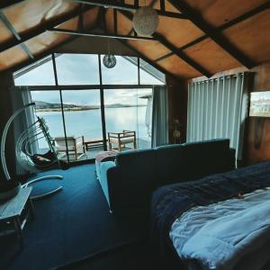 a bedroom with a bed and a view of the water at Uros Tikarani hotel in Puno