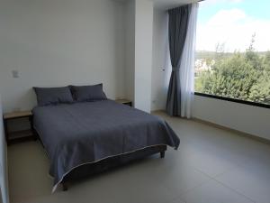 - une chambre avec un lit et une grande fenêtre dans l'établissement Apartamento Zipa 301, à Paipa