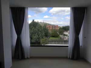 une fenêtre avec vue sur un bâtiment dans l'établissement Apartamento Zipa 301, à Paipa