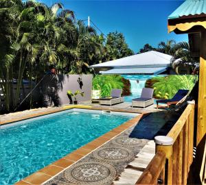 a swimming pool with two chairs and a resort at Baz créole in Deshaies