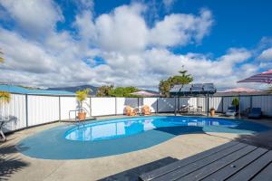 una piscina con un banco junto a una valla en ASURE Fountain Resort Motel en Nelson