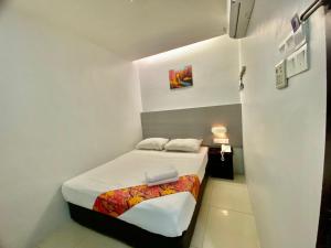 Habitación blanca pequeña con cama. en Best View Hotel Puchong, en Puchong
