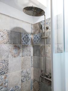 a bathroom with a shower with blue and white tiles at L83 - rooms and apartments in Lisbon