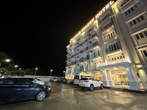un gran edificio con coches estacionados en un estacionamiento en HO TRAM GOLDEN HOTEL, en Thuận Biên