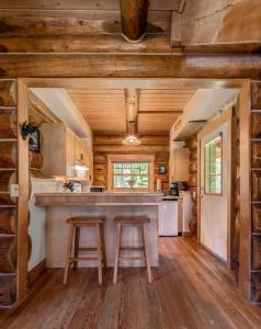 una cocina con dos taburetes en una cabaña de madera en Moberly Lodge, en Golden