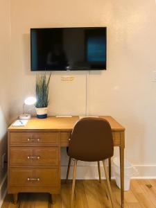a desk with a chair and a television on a wall at Oakdale Suites - Master Property in Medford