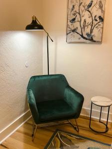 een groene stoel in een kamer naast een lamp bij Oakdale Suites - Master Property in Medford