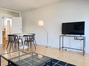a living room with a table and chairs and a tv at One Bedroom Apartment In Valby, Langagervej 64, 2 in Copenhagen