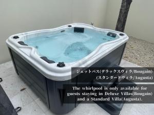 uma banheira de hidromassagem num quarto com uma placa em villa LIFE INDAH sumuide em Nago