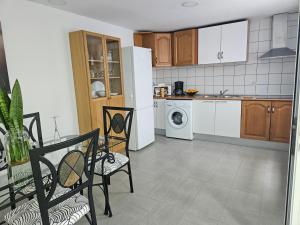 uma cozinha com um frigorífico branco, uma mesa e cadeiras em El Caramelito 3 em San Bartolomé