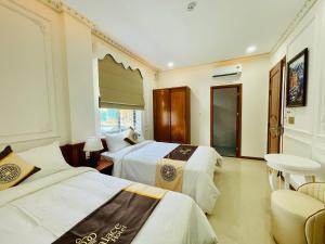 クアンガイにあるNEW PALACE HOTELのベッド2台と窓が備わるホテルルームです。