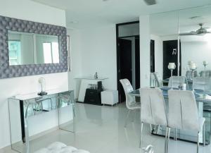 a dining room with a glass table and white chairs at Apartamento moderno y centrado en Barranquilla in Barranquilla