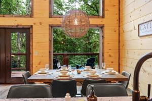 a dining room with a table and chairs and a chandelier at New Cozy Mountain Cabin Hot Tub Near Downtown in Gatlinburg