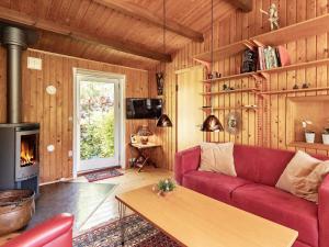 sala de estar con sofá rojo y chimenea en Holiday home Vordingborg XI en Vordingborg