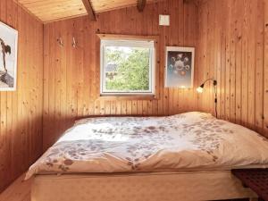 Łóżko w drewnianym pokoju z oknem w obiekcie Holiday home Vordingborg XI w mieście Vordingborg