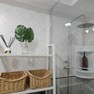 uma casa de banho com cestos numa prateleira e um chuveiro em El Caramelito 3 em San Bartolomé