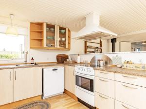 uma cozinha com electrodomésticos brancos e uma grande janela em Holiday home Karrebæksminde IX em Karrebæksminde