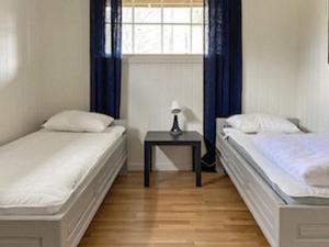 dwa łóżka w pokoju ze stołem i oknem w obiekcie Holiday home Tynset w mieście Tynset