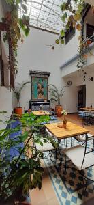 Villa del Prado في ميديلين: غرفة بها طاولات ونباتات خزف