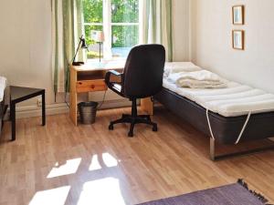 1 dormitorio con cama, escritorio y silla en Holiday home Utansjö, en Utansjö