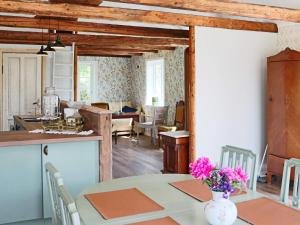 a kitchen and dining room with a table with flowers on it at 4 person holiday home in ROLFSTORP-By Traum in Rolfstorp