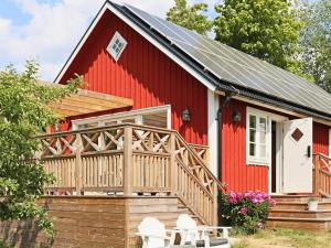 a red barn with a porch and two chairs at 4 person holiday home in ROLFSTORP-By Traum in Rolfstorp