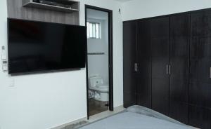 a bathroom with a flat screen tv and a toilet at Apartamento moderno y centrado en Barranquilla in Barranquilla